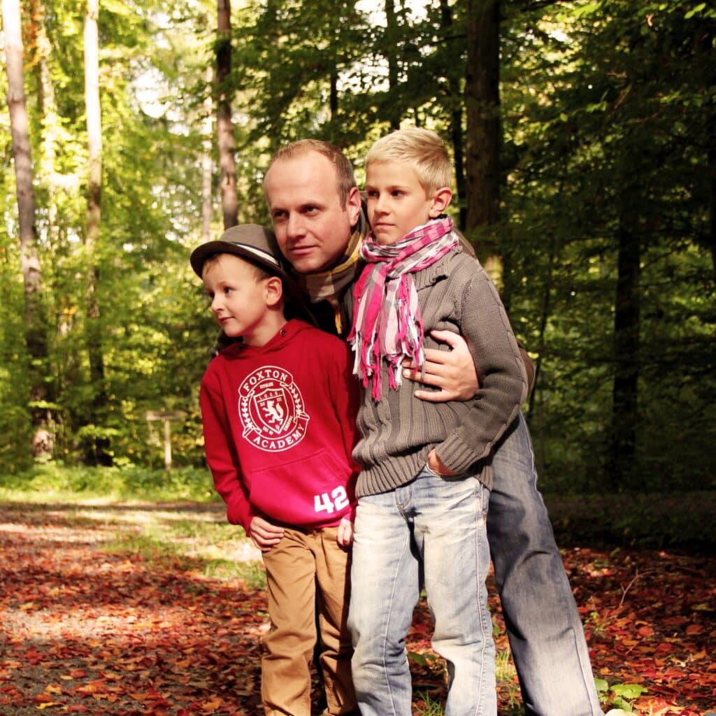 Man embracing two children outdoors, illustrating estate planning for minor children.
