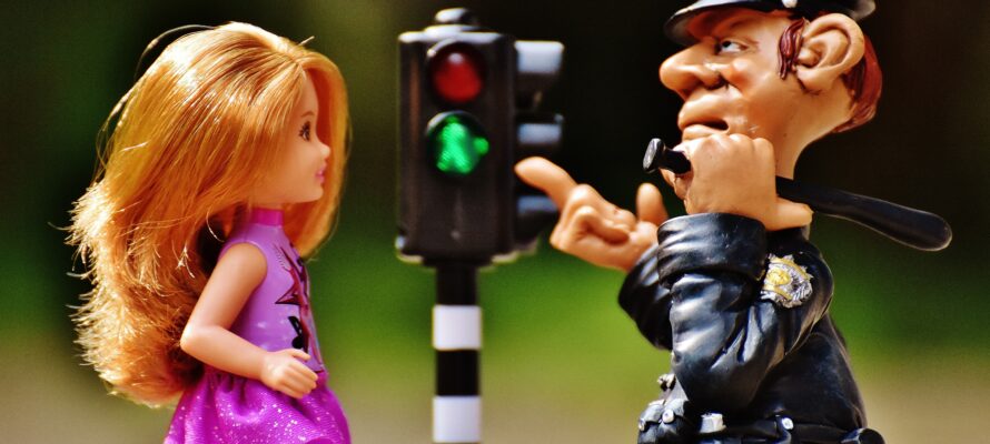 Police figurine pointing at a doll beside a traffic light, illustrating conservatorship restrictions.