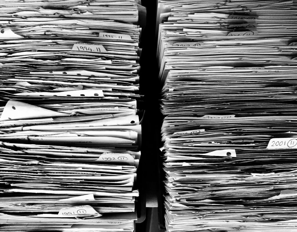 Stacks of dated paper files illustrating the paperwork burden associated with conservatorship.